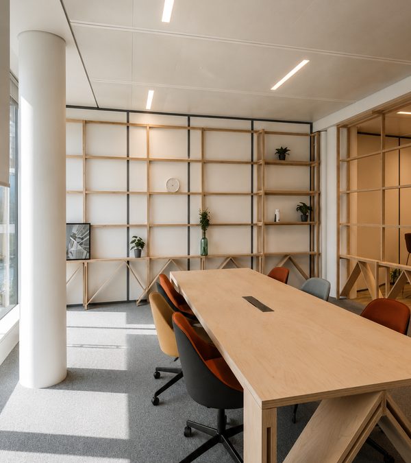 La share zone : grande table commune sous les étagères bois